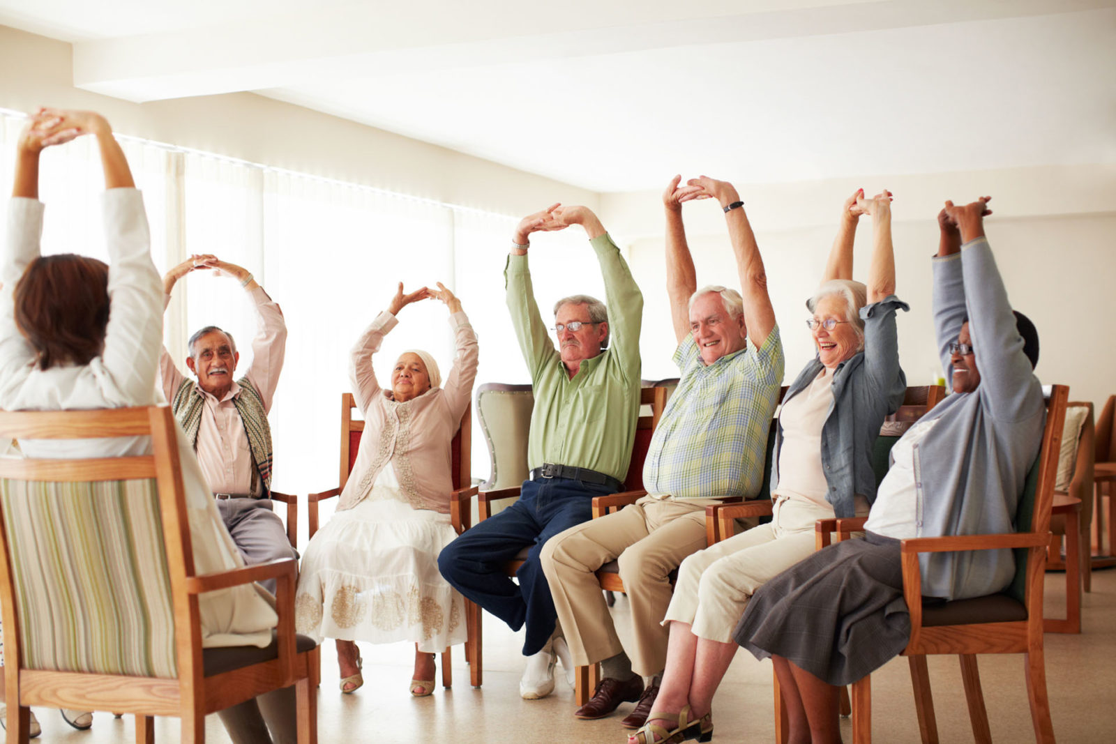 Daily stretching exercise routine for a group of cheerful elderly people at an old age home